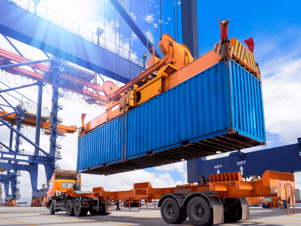 Container being loaded onto a truck carrier for transport out of the port yard by a crane operator