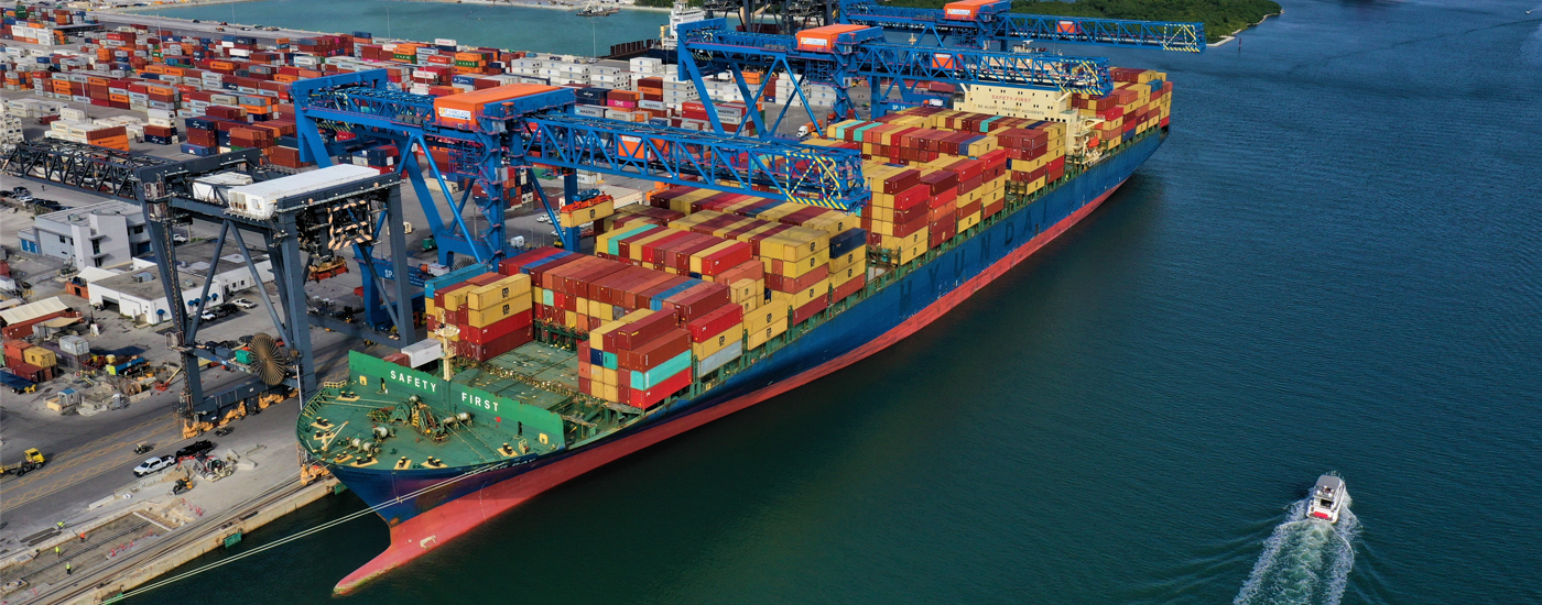 Large vessel docked at the port, heavily loaded with numerous containers