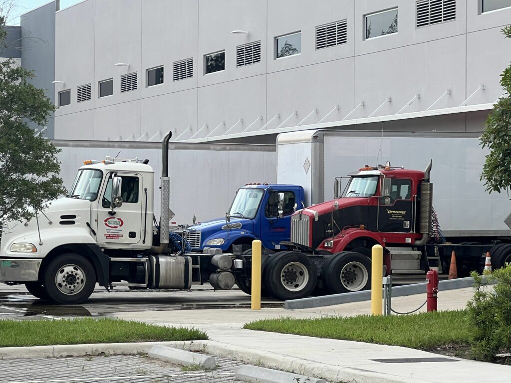 Trucking companies parked outside of Challenge Warehousing waiting to be loaded